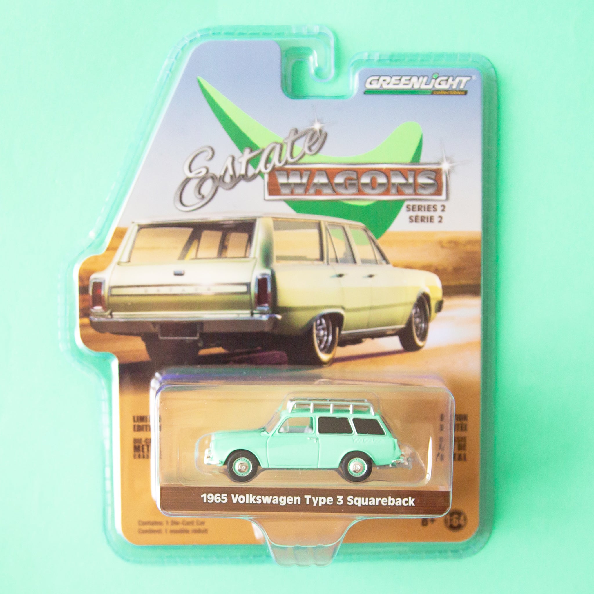 A green station wagon toy car in the packaging. 