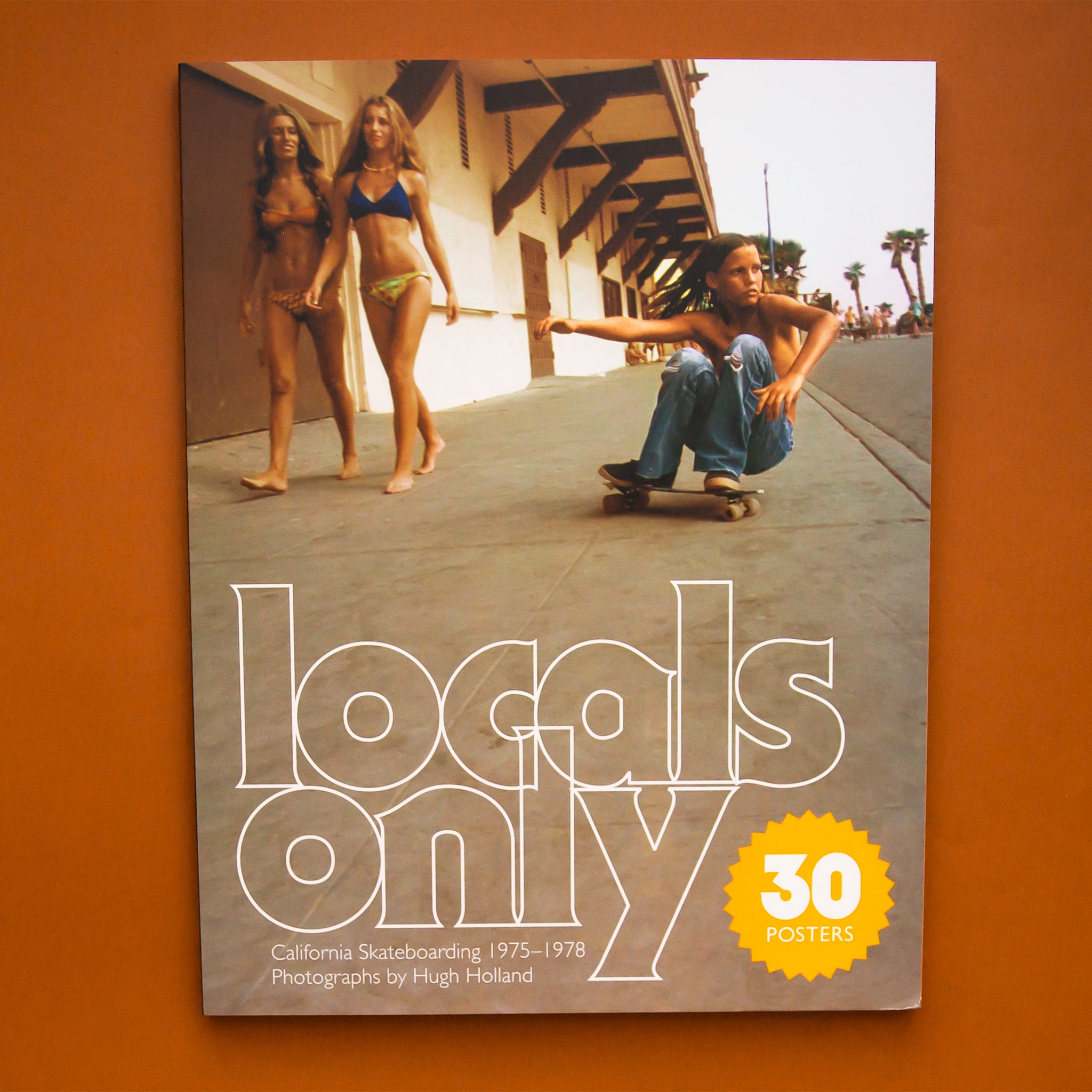 On a tan background is a neutral book with a skater on the front and the title that reads, &quot;Locals only&quot;. 