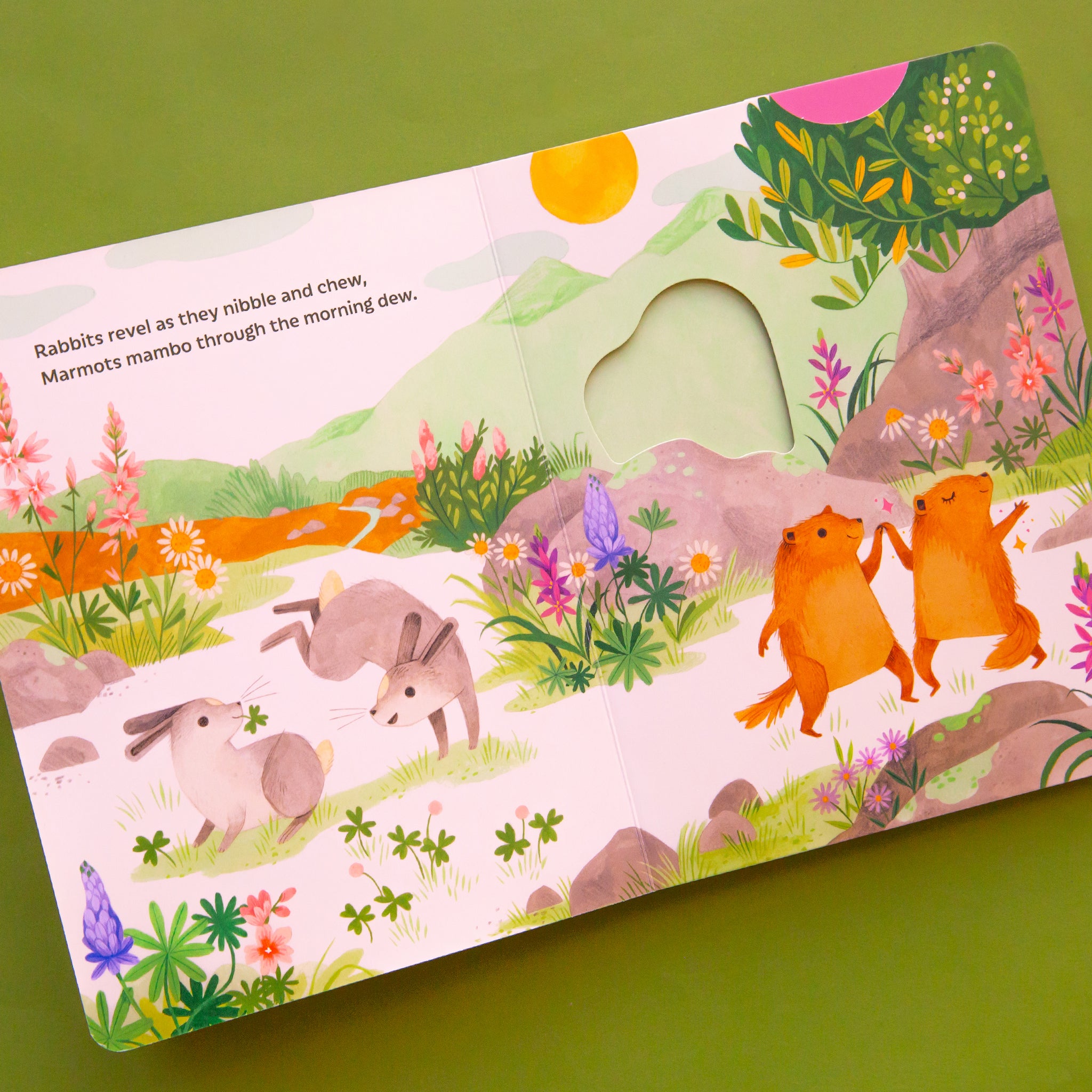 A page opened to the book that shows vibrant illustrations of forest animals and florals along with text. 