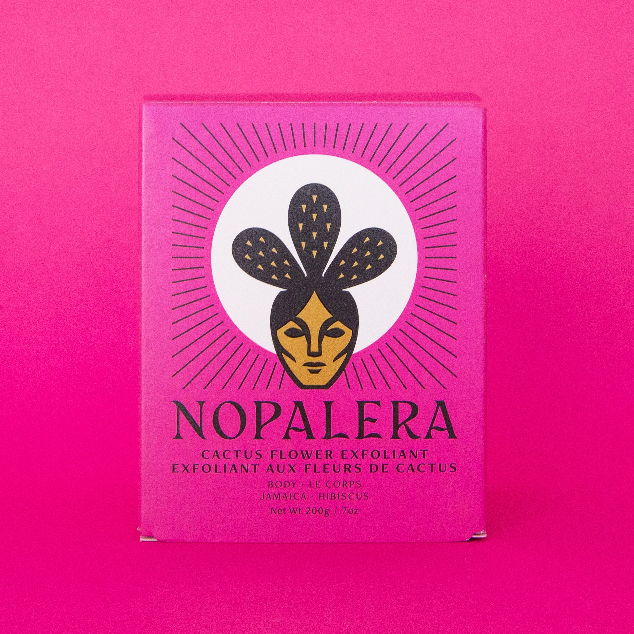 On a pink background is a hot pink packaging filled with a jar of cactus flower exfoliant. 