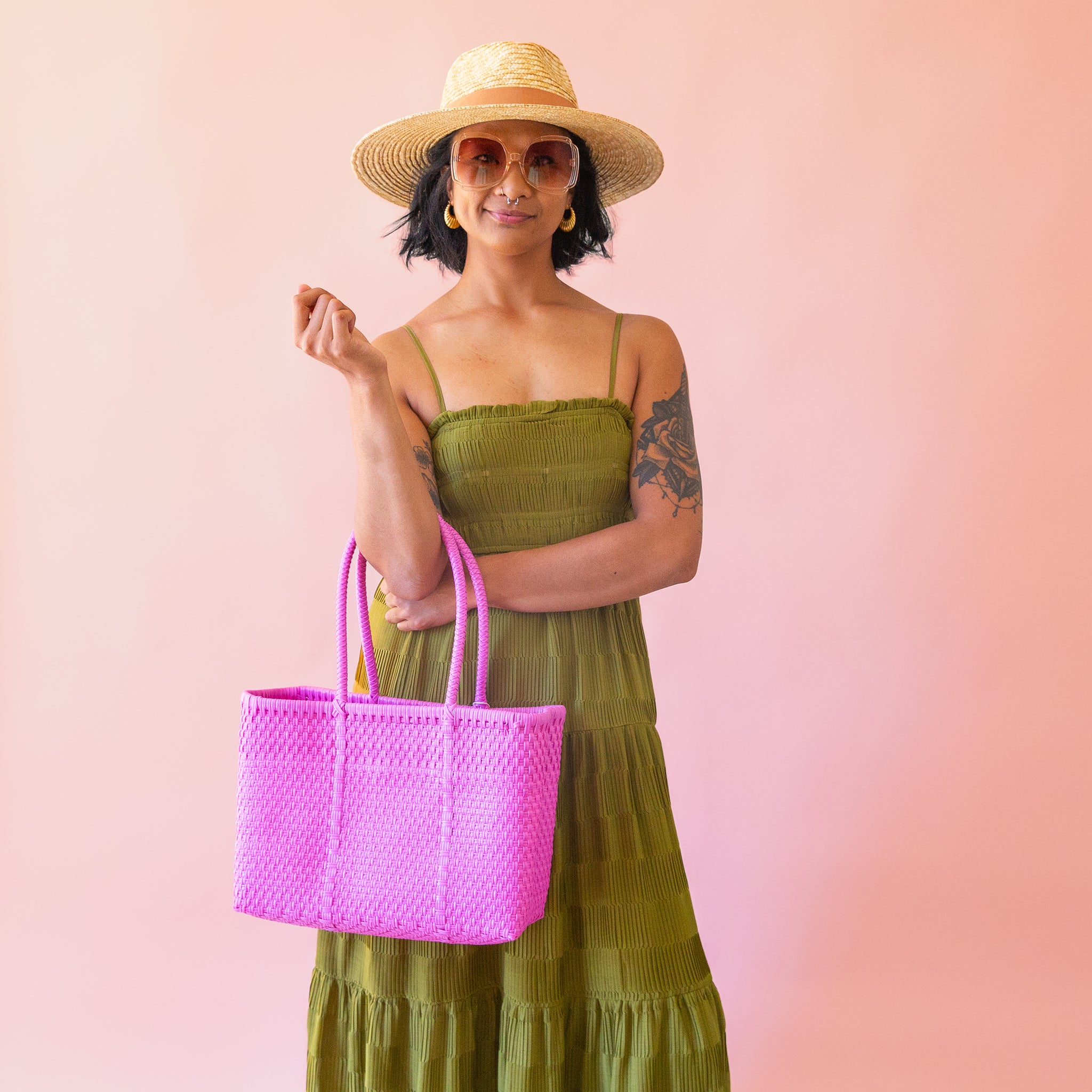 On a pink background is a hot pink woven bag.