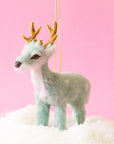 On a pink background is a photo of the largest fur reindeer option with antlers. 
