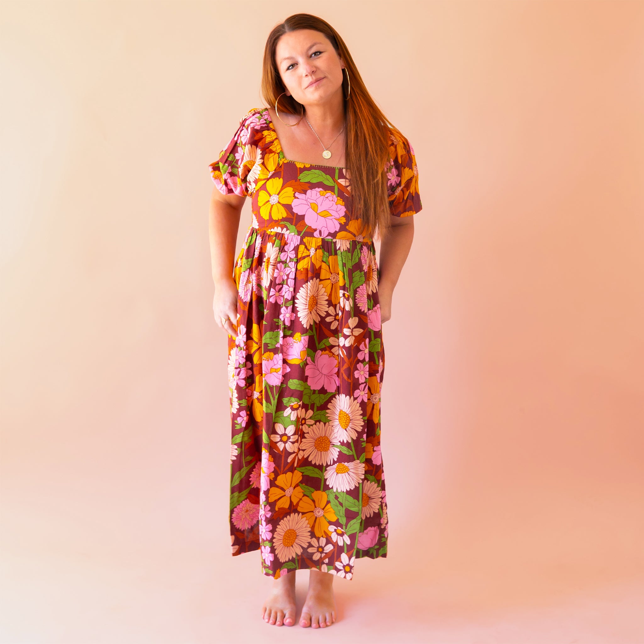 A mutli colored floral print maxi dress with puff sleeves and pockets. A mutli colored floral print maxi dress with puff sleeves and pockets.