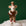 On a green background is a white felt mouse ornament with a brown outfit on and holding a gingerbread cookie. 