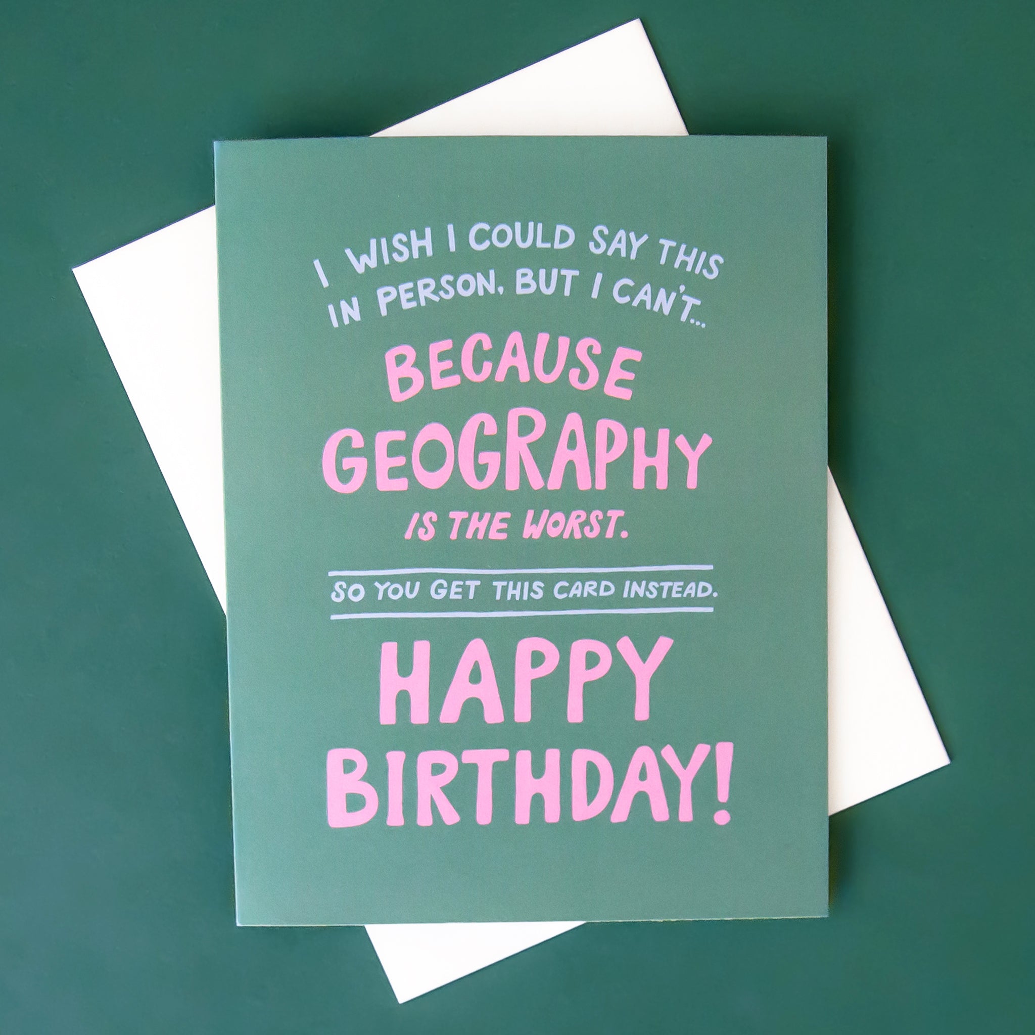 On a green background is a green card with pink text that reads, "I Wish I Could Say This In Person. But I Can't... Because Geography Is The Worst. So You Get This Card Instead. Happy Birthday!". 