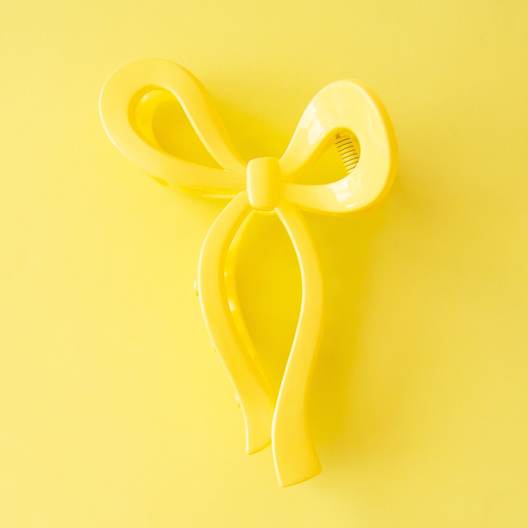 A yellow knotted bow shaped hair clip.