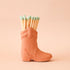 Terracotta ceramic boot match holder filled with a bundle of blue dipped matches.