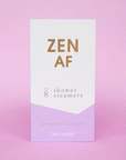 Eight lilac purple shower steamer tablets inside of a purple and white box that reads, "Zen AF" in gold text across the front.