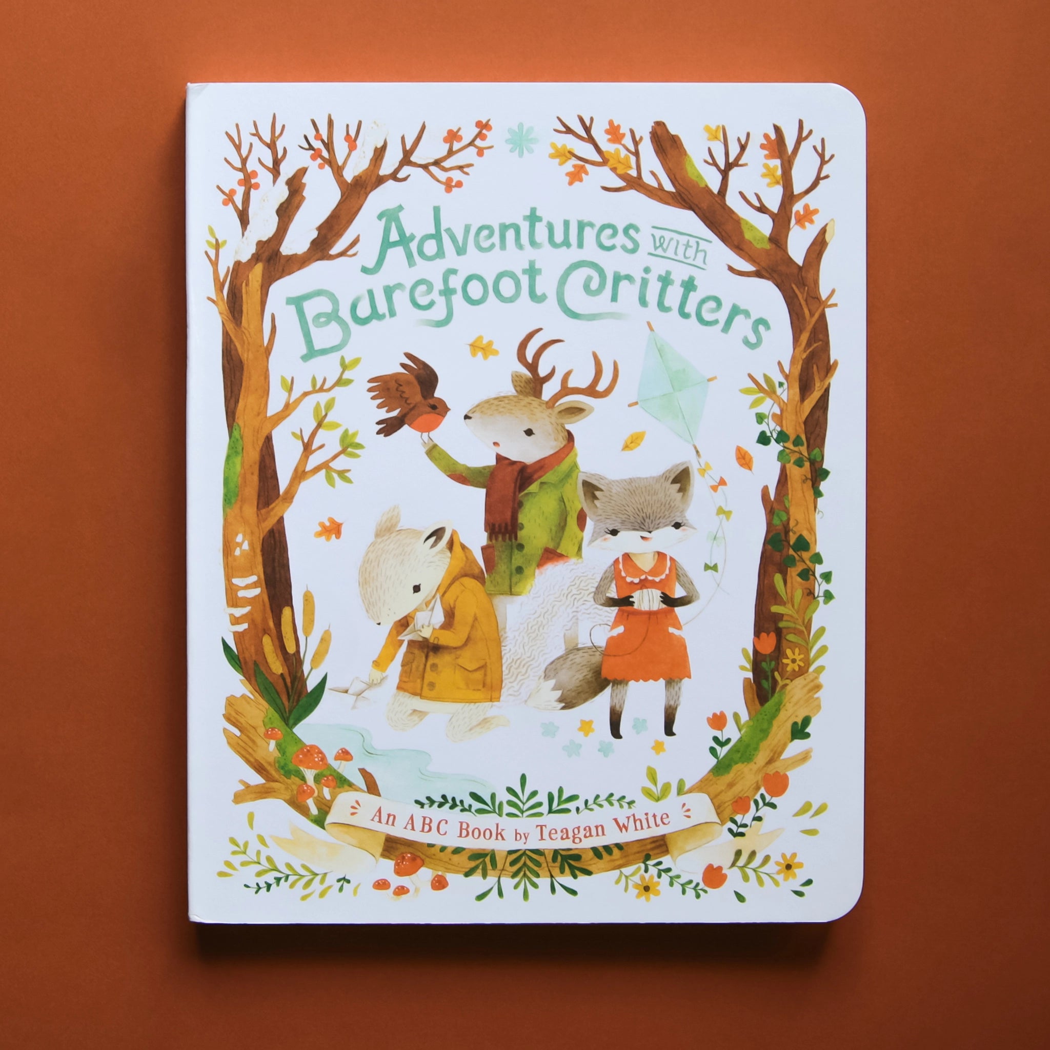 An illustrated children&#39;s book titled &quot;Adventures with Barefoot Critters - an ABC Book by Teagan White&quot;. Cover illustration shows water color style woods with person-like woodland creatures including a fox, deer and squirrel wearing clothes.