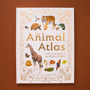 The front cover of the book reads 'The Animal Atlas': A pictorial Guide to the World's Wildlife' in gold lettering. The text is surround by a variety of animals including tigers, turtles, giraffes, and more. The cover of the book is bordered with elegant gold detailing.