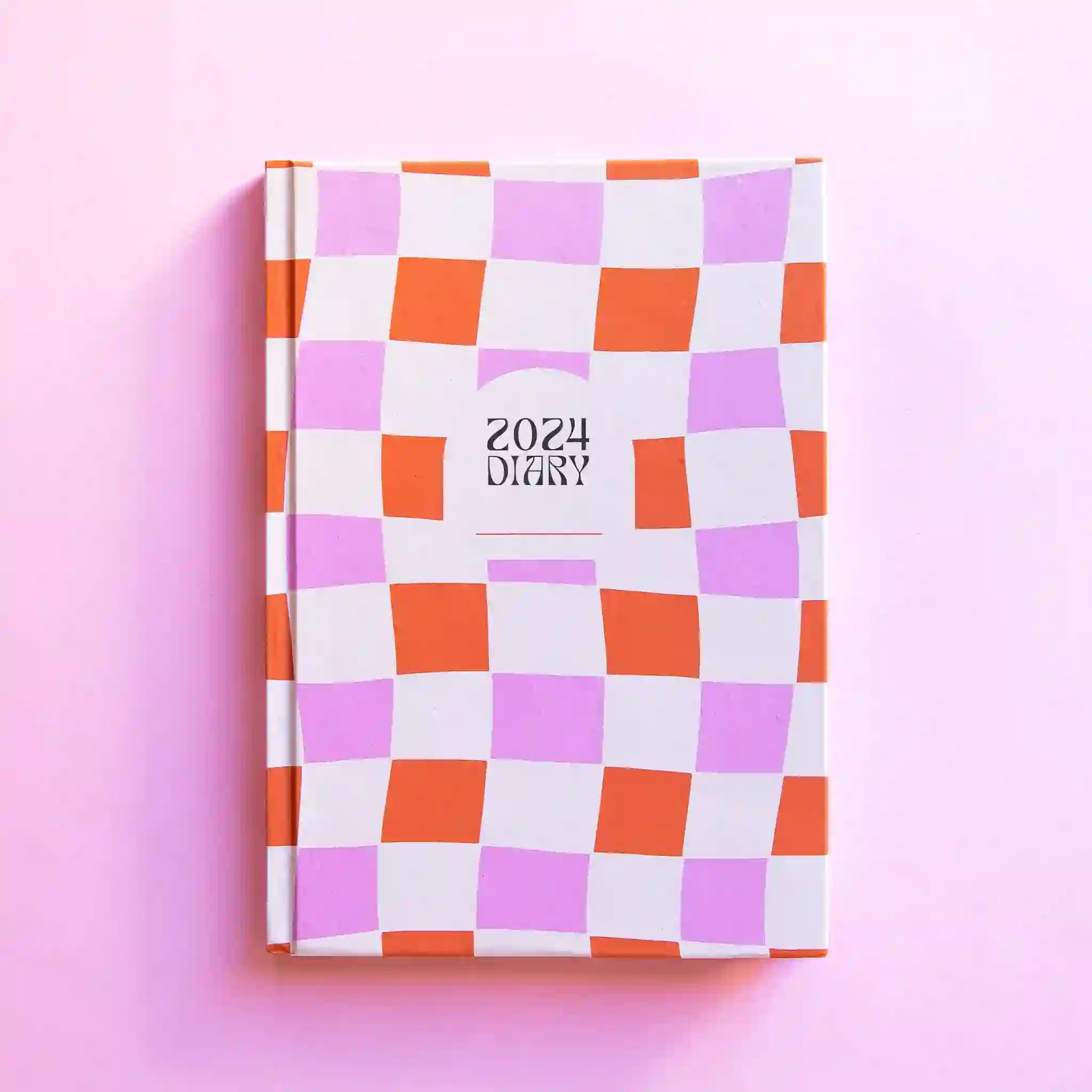 A pink and orange hardback diary with black text in the center that reads, "2024 Diary".