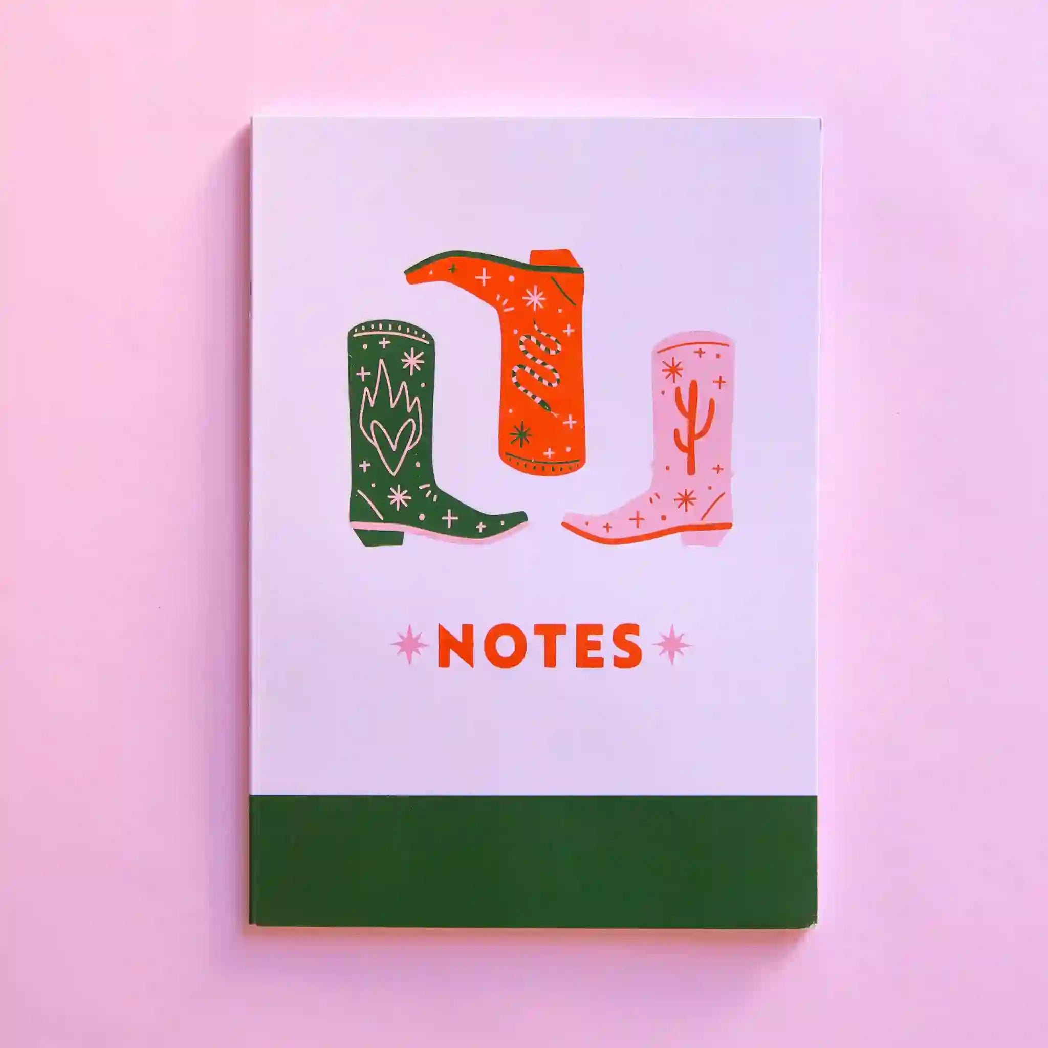 On a pink and green notepad with a red, pink, and green cowboy boot along with red text below that reads, "NOTES".
