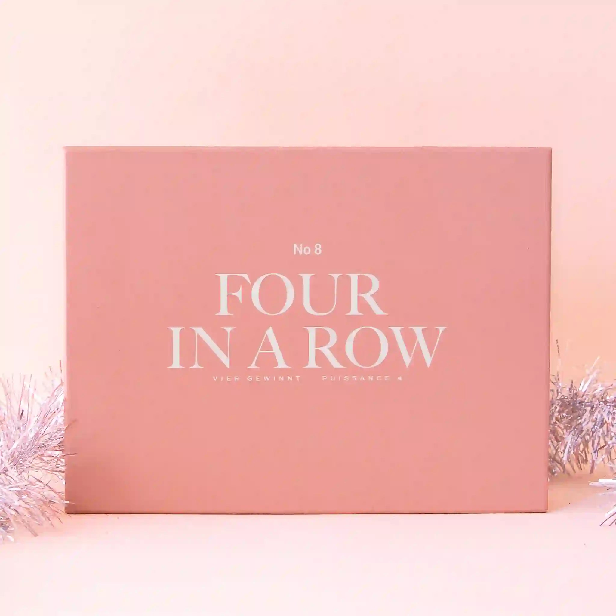 A pink box filled with a four in a row board game and white text that reads, &quot;No 8 Four In A Row&quot;.