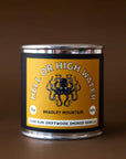 On a brown background is a tin candle with a yellow label featuring a octopus graphic and text arched above it that reads, "Hell or High Water Bradley Mountain".