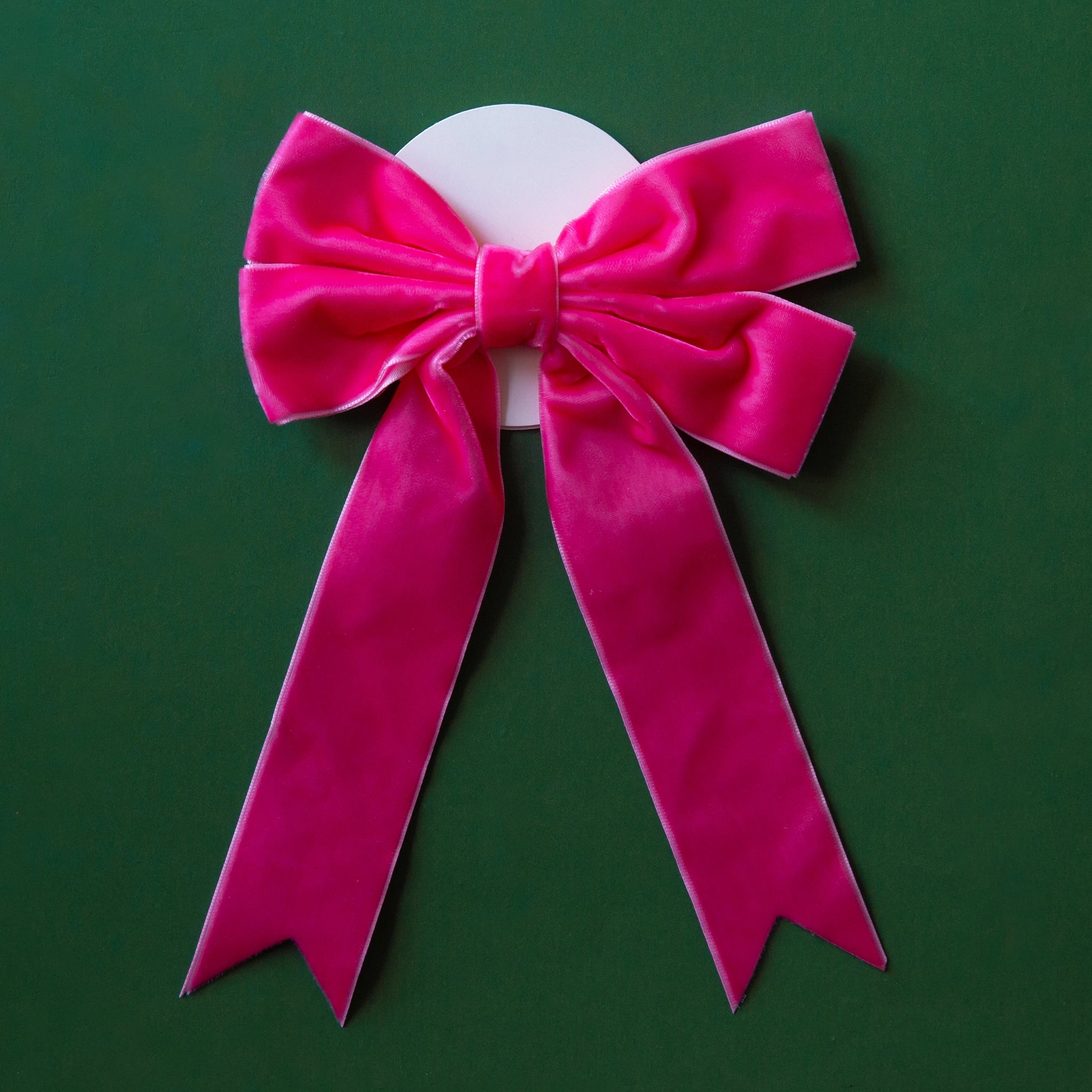 On a green background is a bright pink velvet bow.