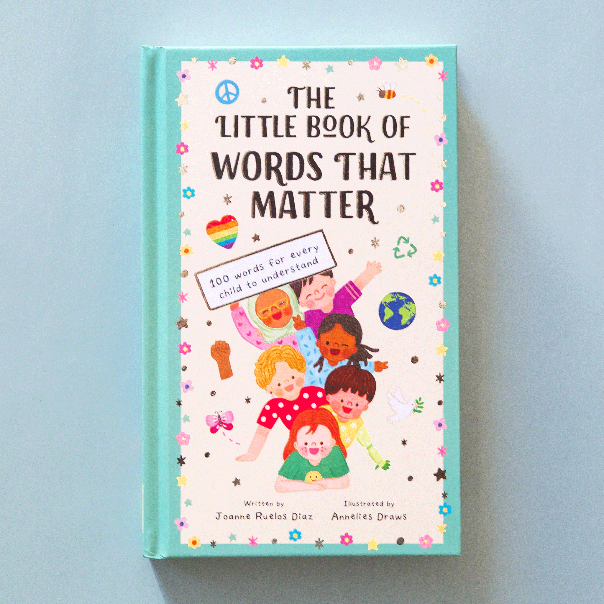 On a blue background is a book with an illustration of children and the title at the top that reads, &quot;The Little Book of Words That Matter&quot;.