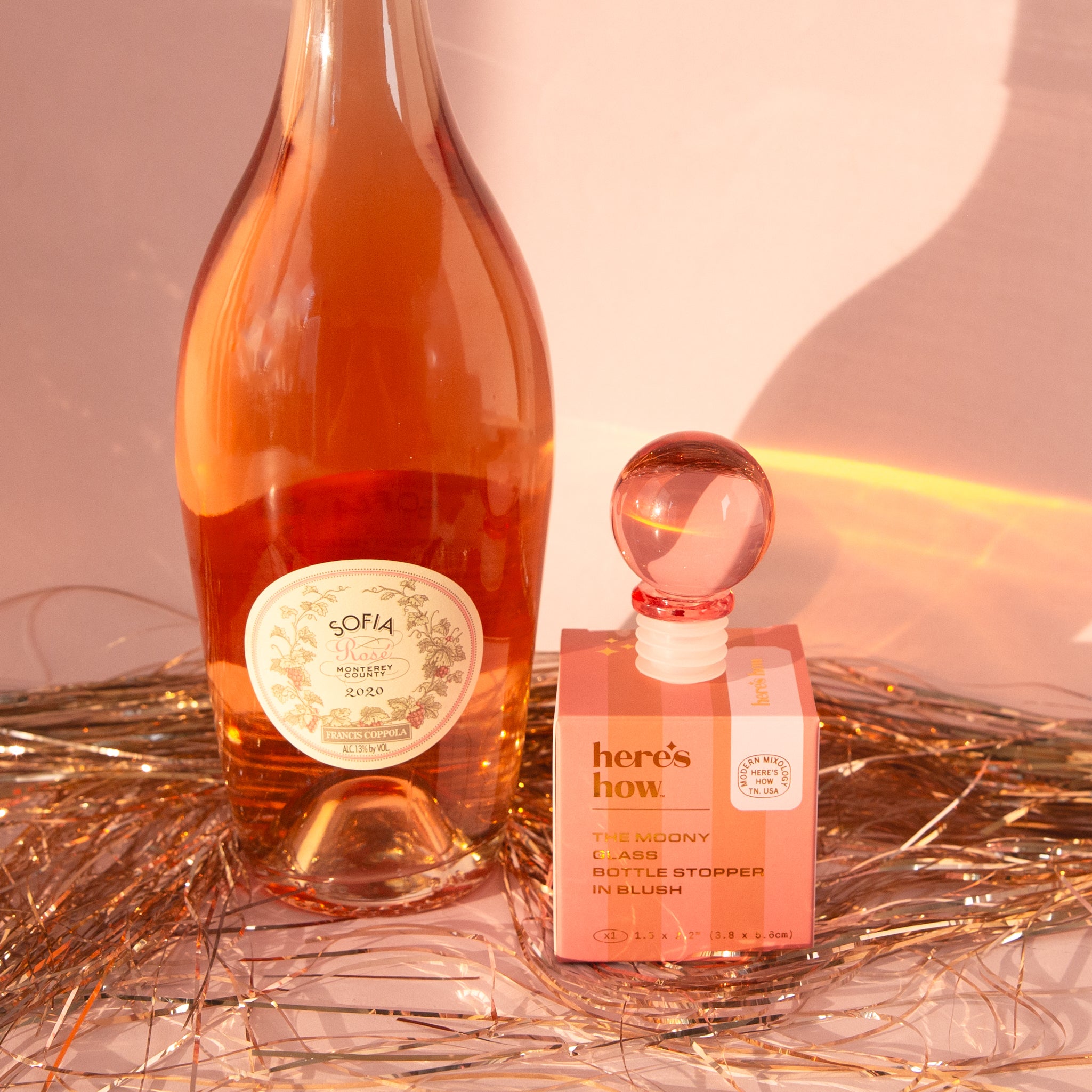 A pink glass round bottle stopper. 