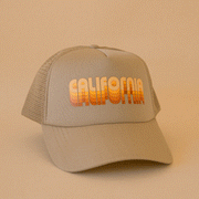 On a tan background is a tan trucker hat with yellow and orange gradient text that reads, "California".