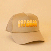 On a tan background is a tan trucker hat with yellow and orange gradient text that reads, "San Diego".