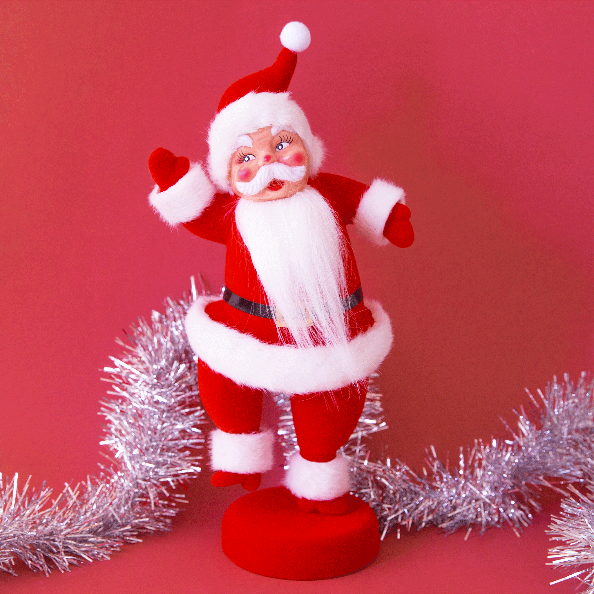 A plastic Santa figurine with a red suit and furry detailing on the cuffs, jacket and hat.