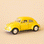 On a tan background is a yellow toy VW bug.