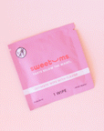 On a light pink background is a hot pink packet of a feminine wipes with text on the front that reads, "sweetums taste below the waist intimate wipe with flavor".