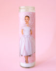 A thin pink prayer candle with a photo of Ariana Grande in a pink dress. 