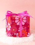 On a pink background is a hot pink and orange floral gift wrap. 