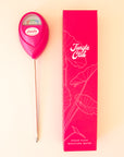 A hot pink moisture meter next to a hot pink box for packaging.