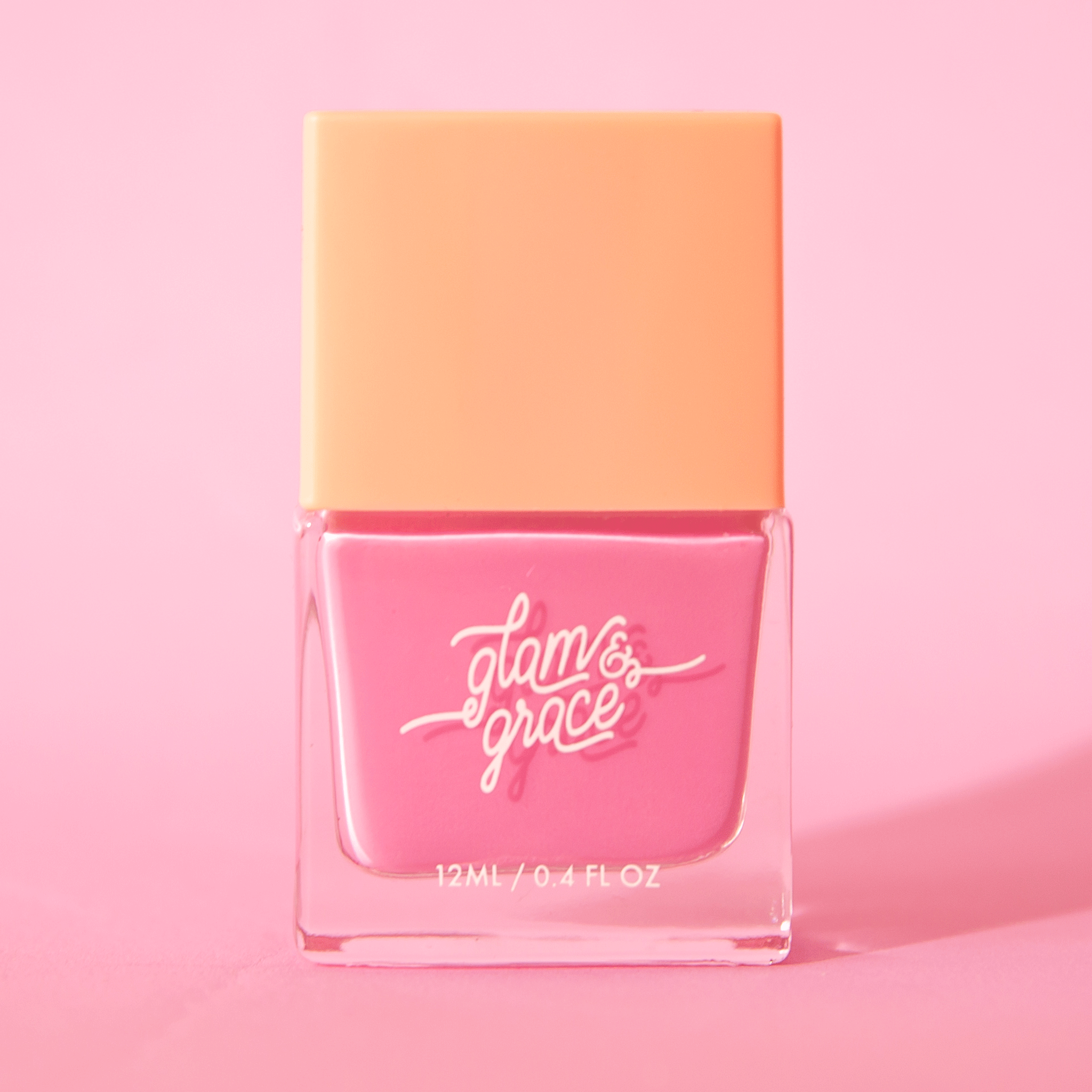 On a pink background is a square nail polish bottle with a bright pink nail polish inside