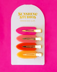 Four vibrant colored creaseless hair clips in orange, pink and yellow shades.