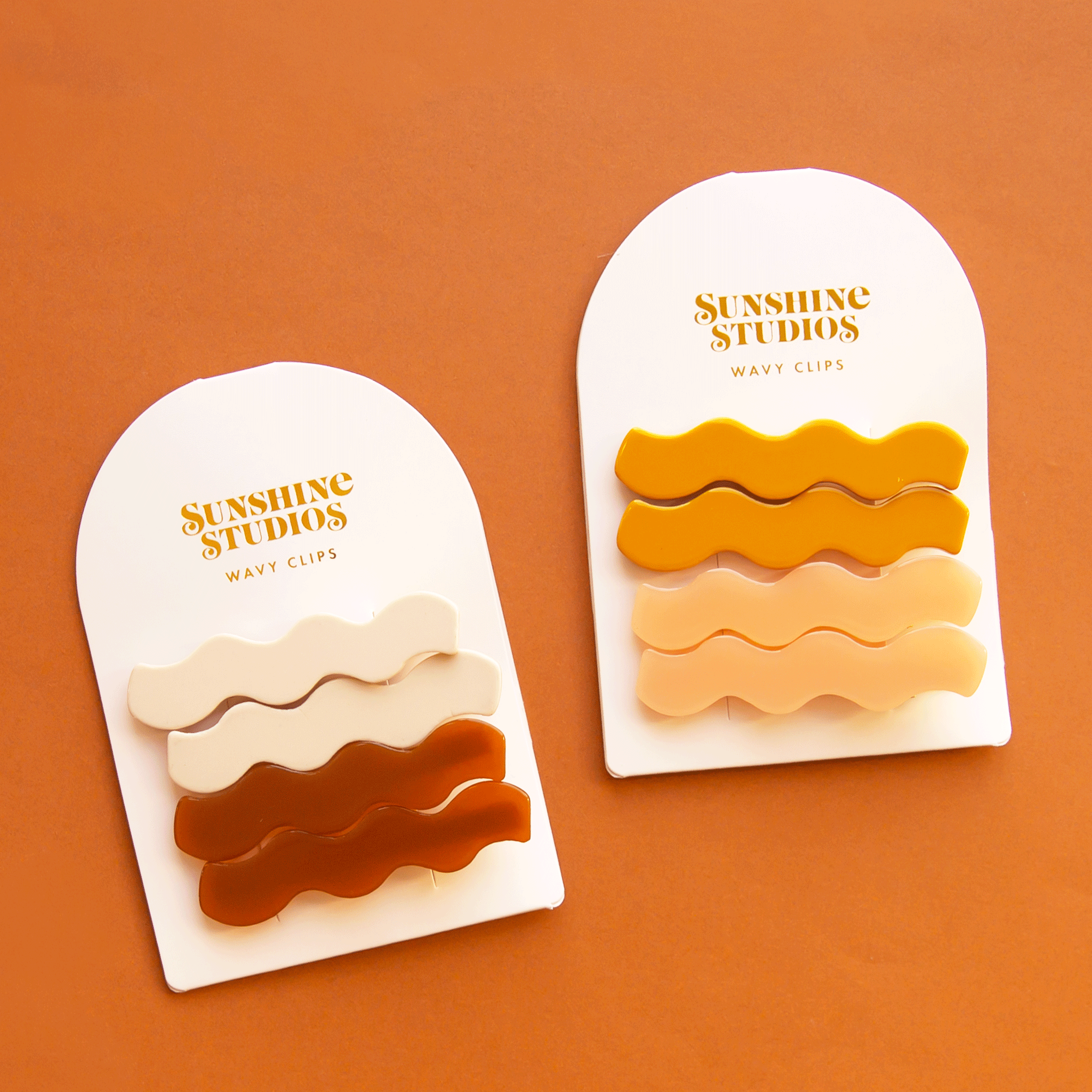 On an orange background is the cognac color way and pink mango version of the wavy hair clip sets.