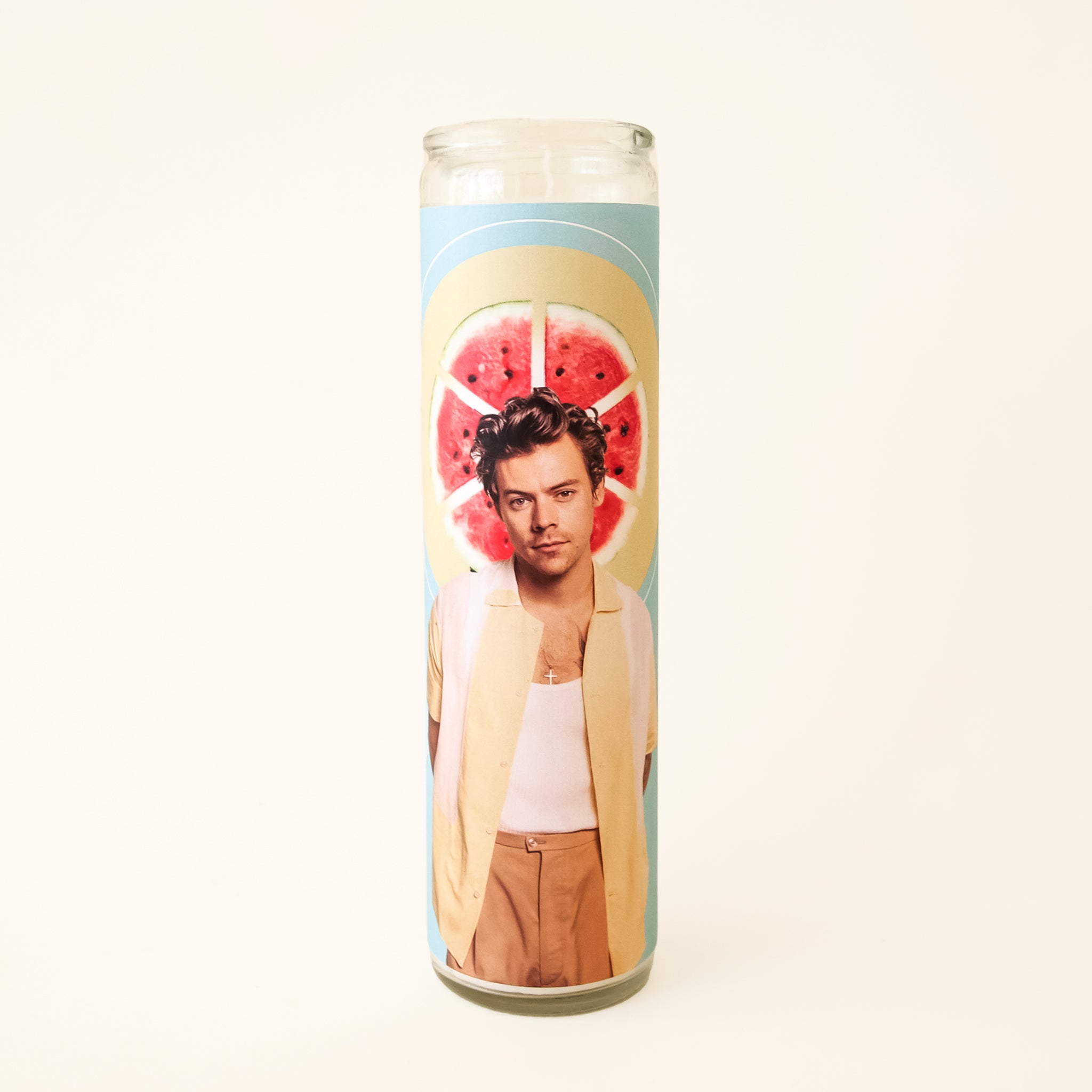 On a white background is a prayer candle with Harry Styles in front of a watermelon on the front.