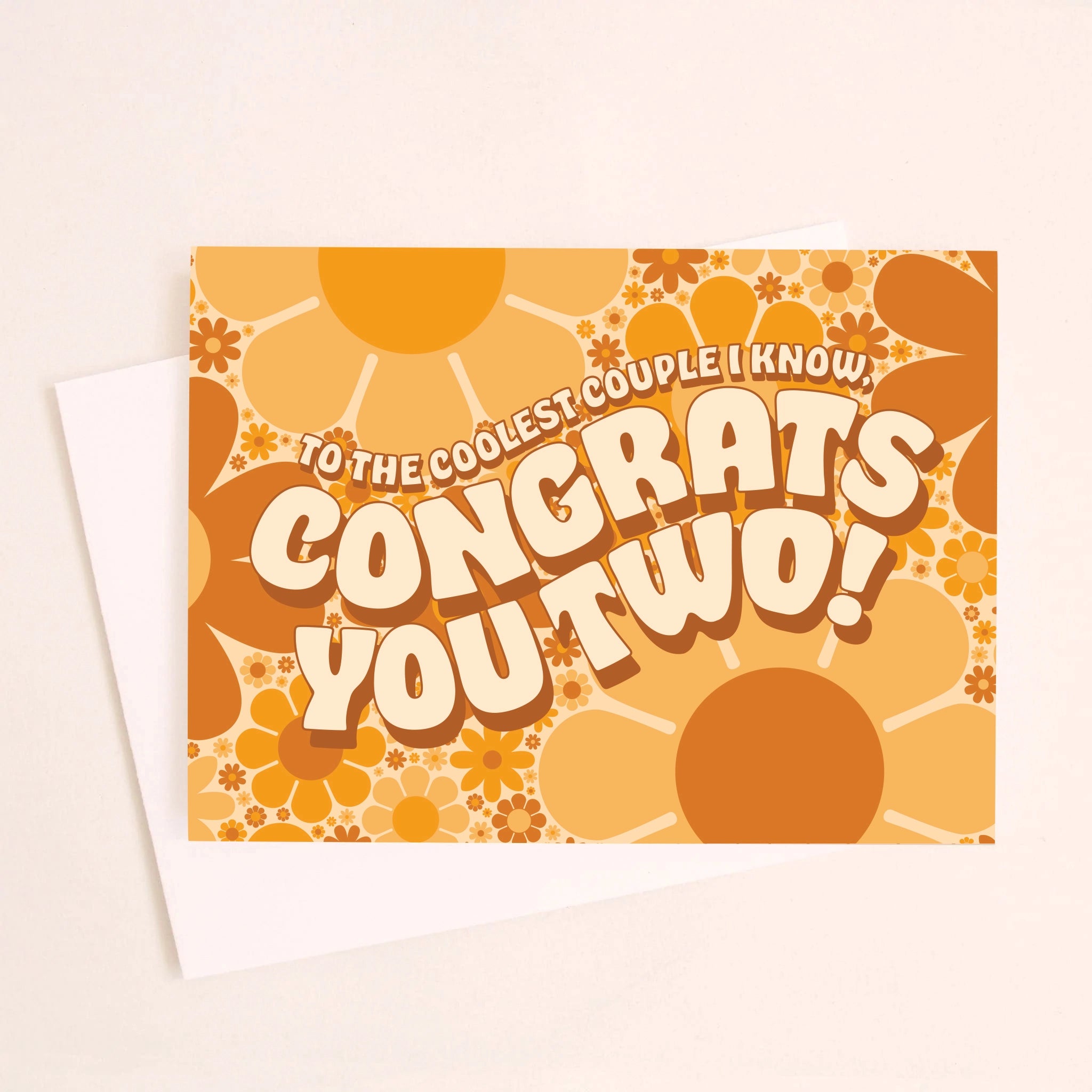 On an ivory background is a daisy print congratulations card with shades of orange and brown along with wavy text in the center that reads, &quot;To The Coolest Couple I Know, Congrats You Two!&quot;.