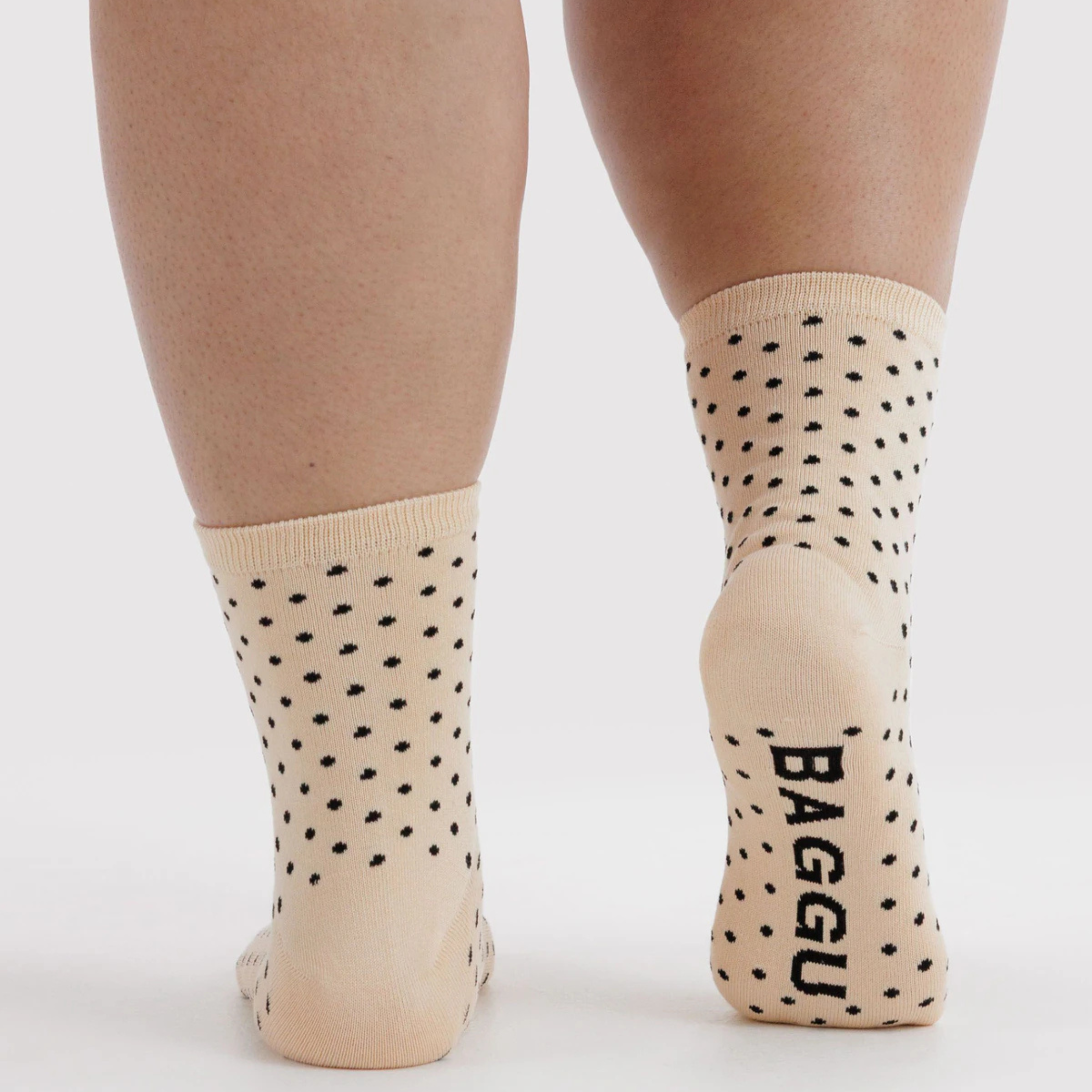 A pair of cream and black micro polka dot socks.