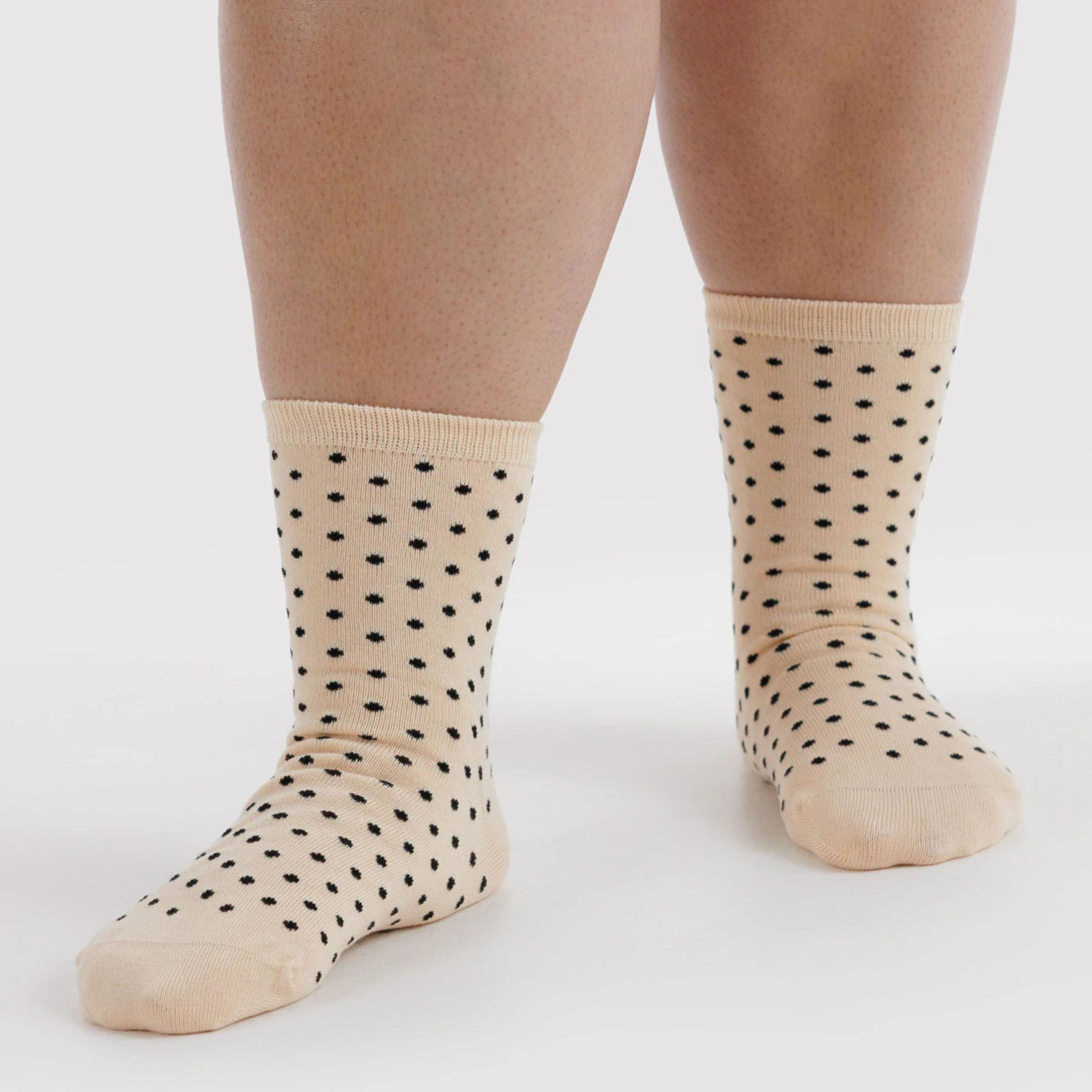 A pair of cream and black micro polka dot socks.