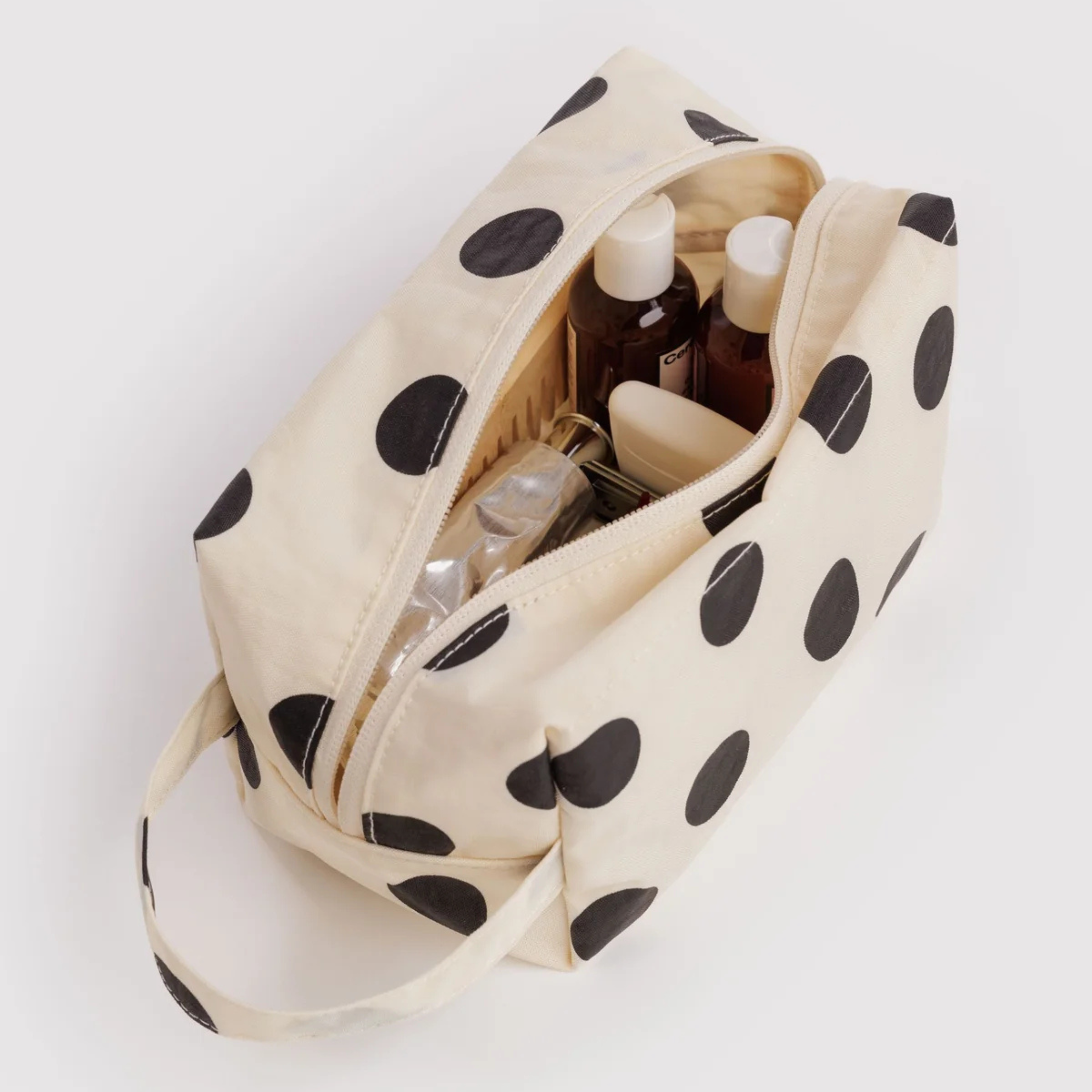 a cream and black polka dot dopp kit bag.