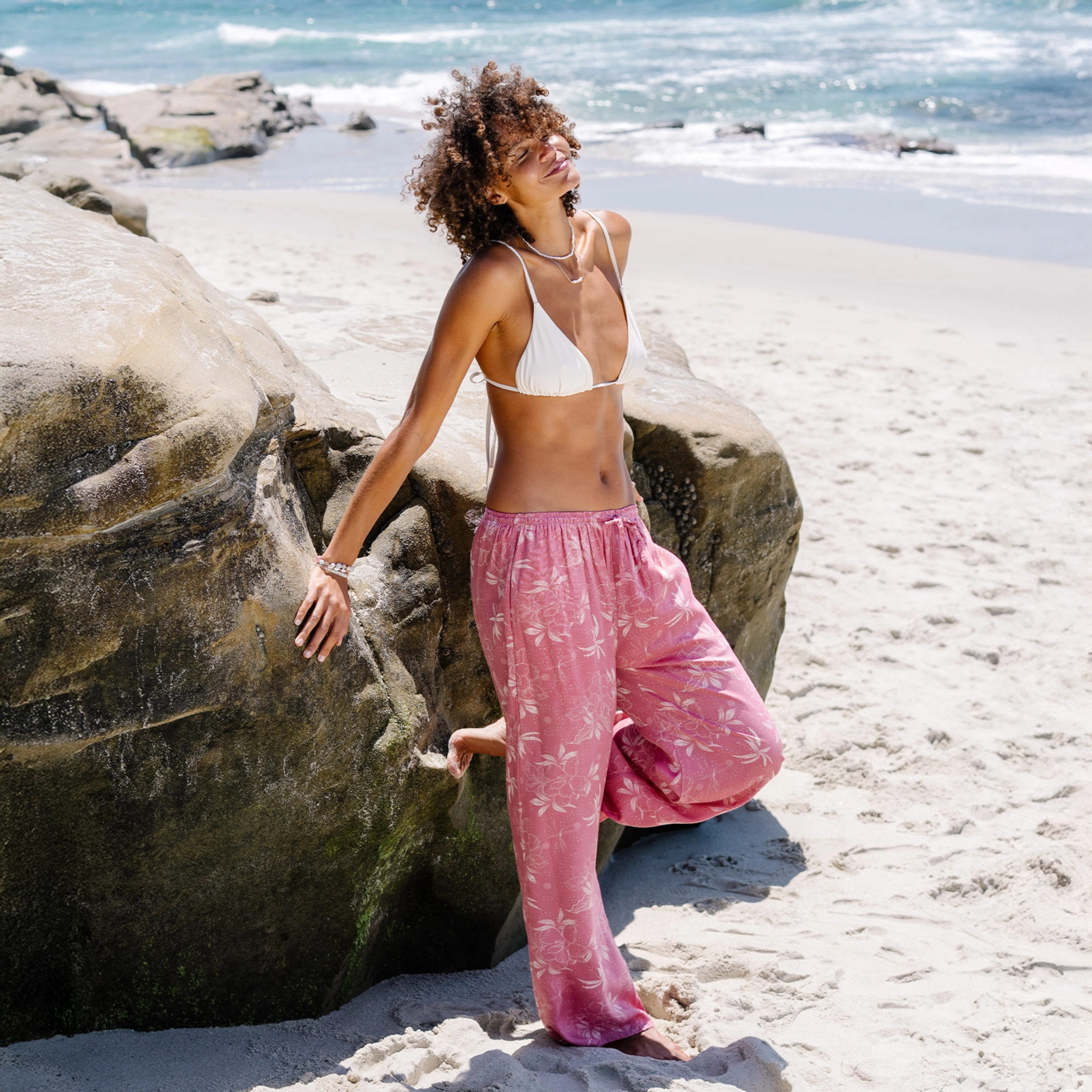 a pair of pink pants with a cream foliage print.