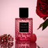 A pink bottle of perfume with black details and a black label with text that reads, 'Voluspa Rosalie'.