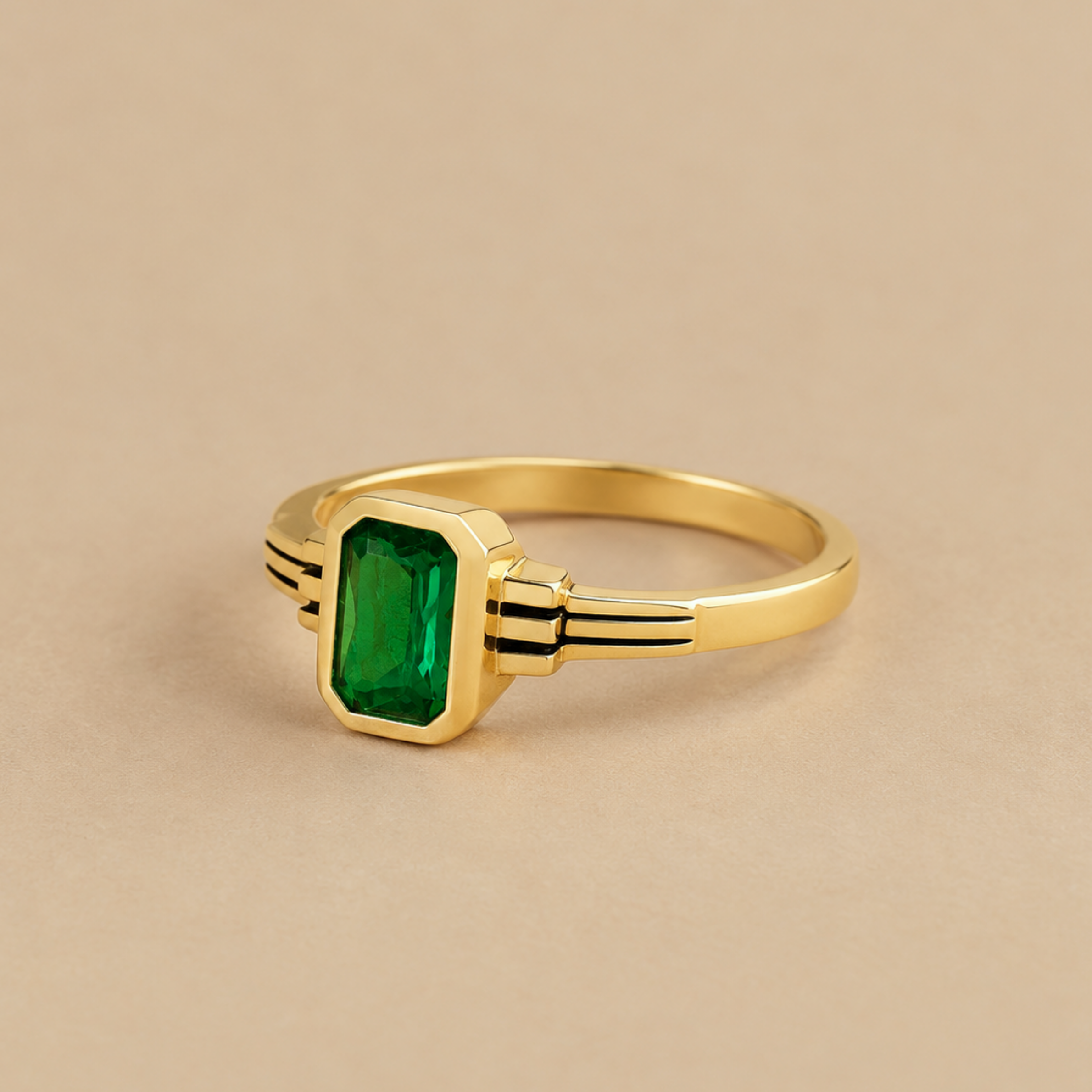 a gold art deco inspired ring with a green stone in the center. 