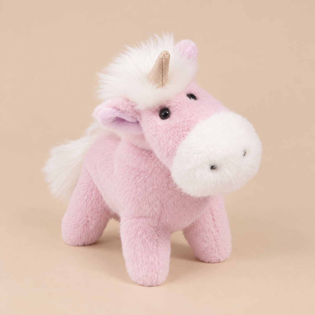 A light purple/pink unicorn shaped stuffed animal. 