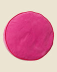 A round hot pink floor cushion. 