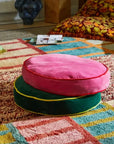 A round hot pink floor cushion. 