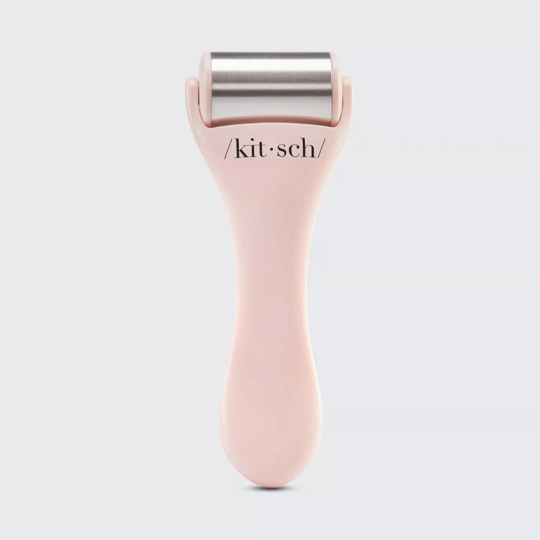On a white background is a light pink and stainless steel facial ice roller. 
