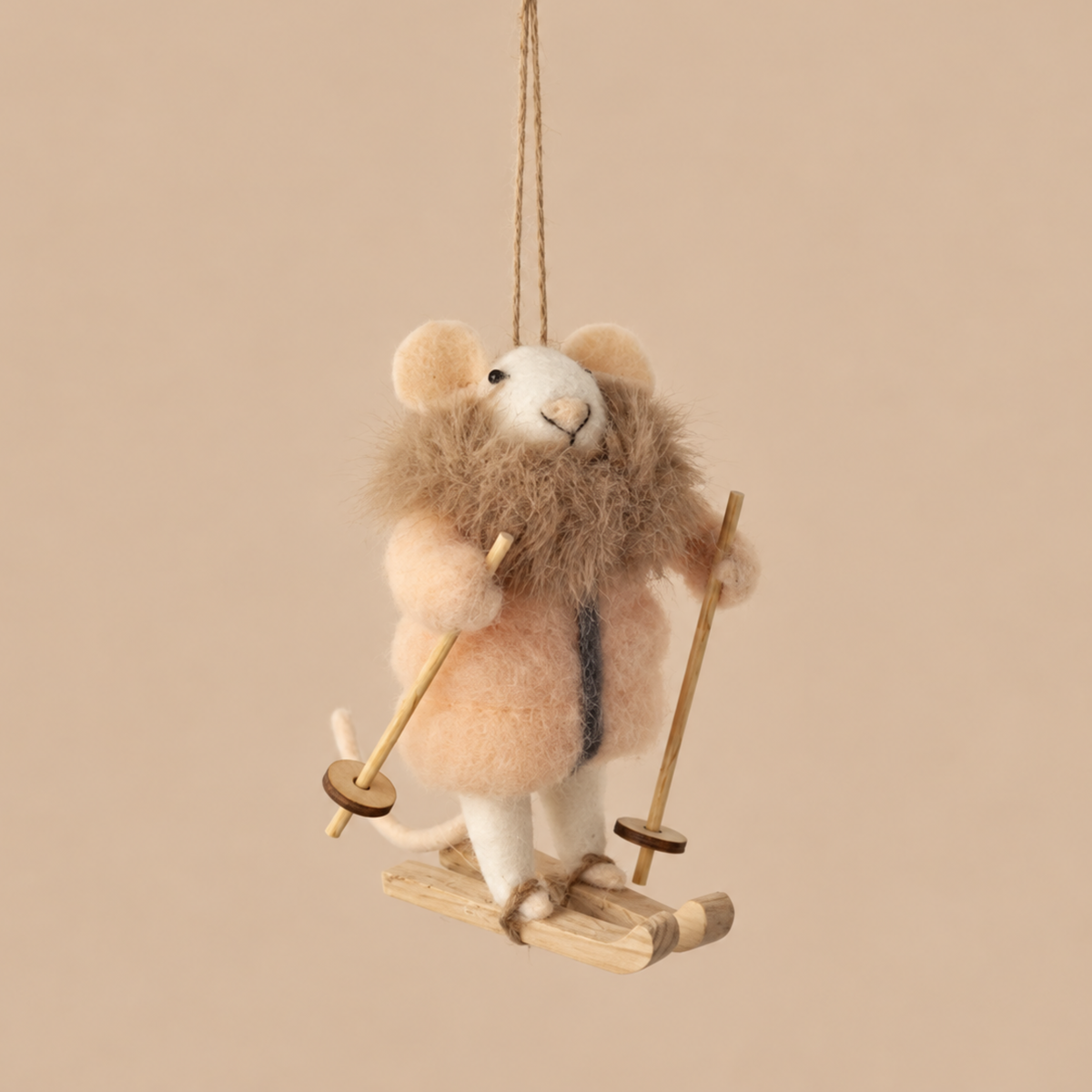 a felt mouse with a pink fur jacket on and a skis