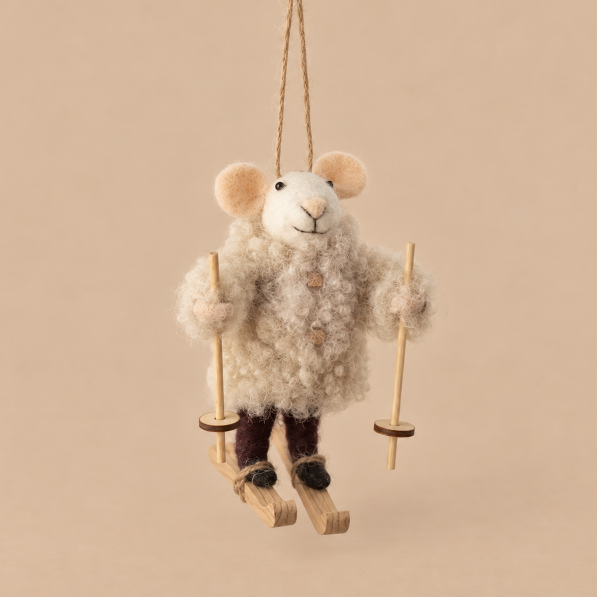 a felt mouse ornament wearing an oatmeal colored jacket and a pair of skis