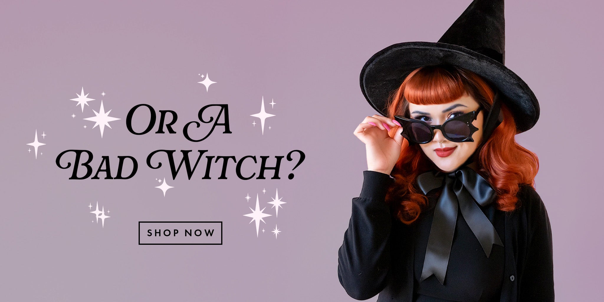 A purple web banner image of a model wearing a black witch hat with red hair.  she is wearing black bat shaped sunglasse and looking at viewer.  the text next to her reads "or a bad witch, shop now"