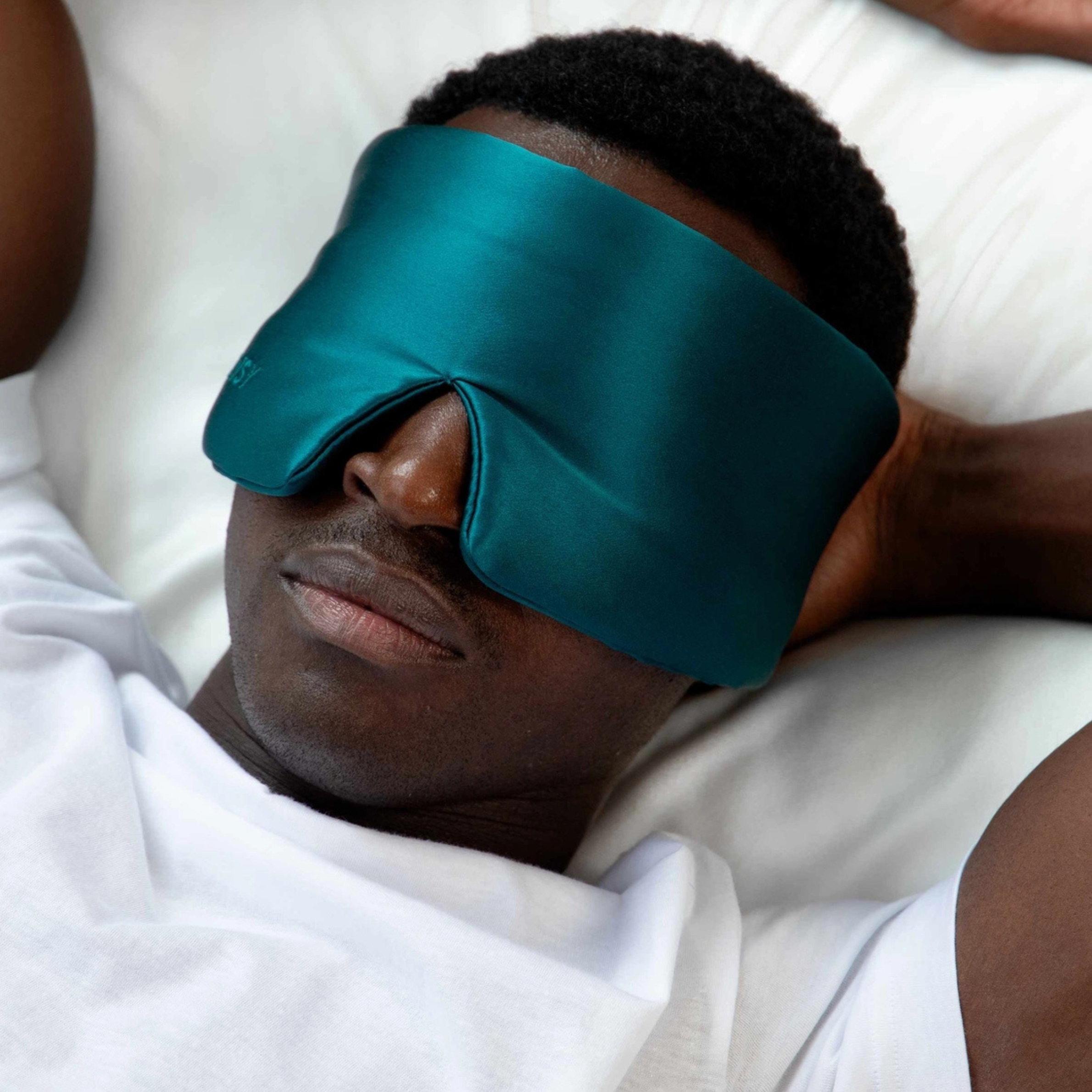 a sapphire green padded sleep mask. 