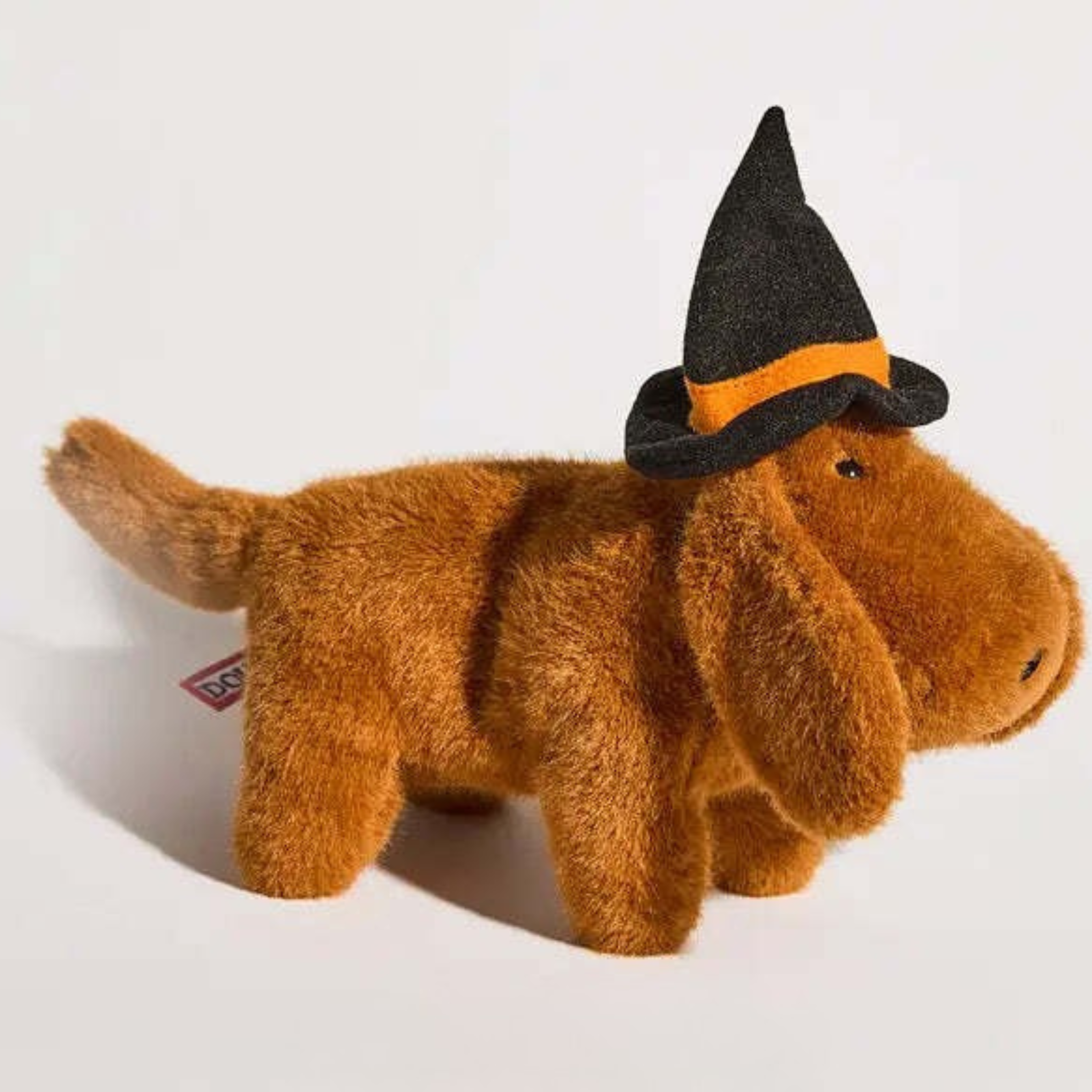a brown dachshund plush toy wearing a black and orange witch hat.