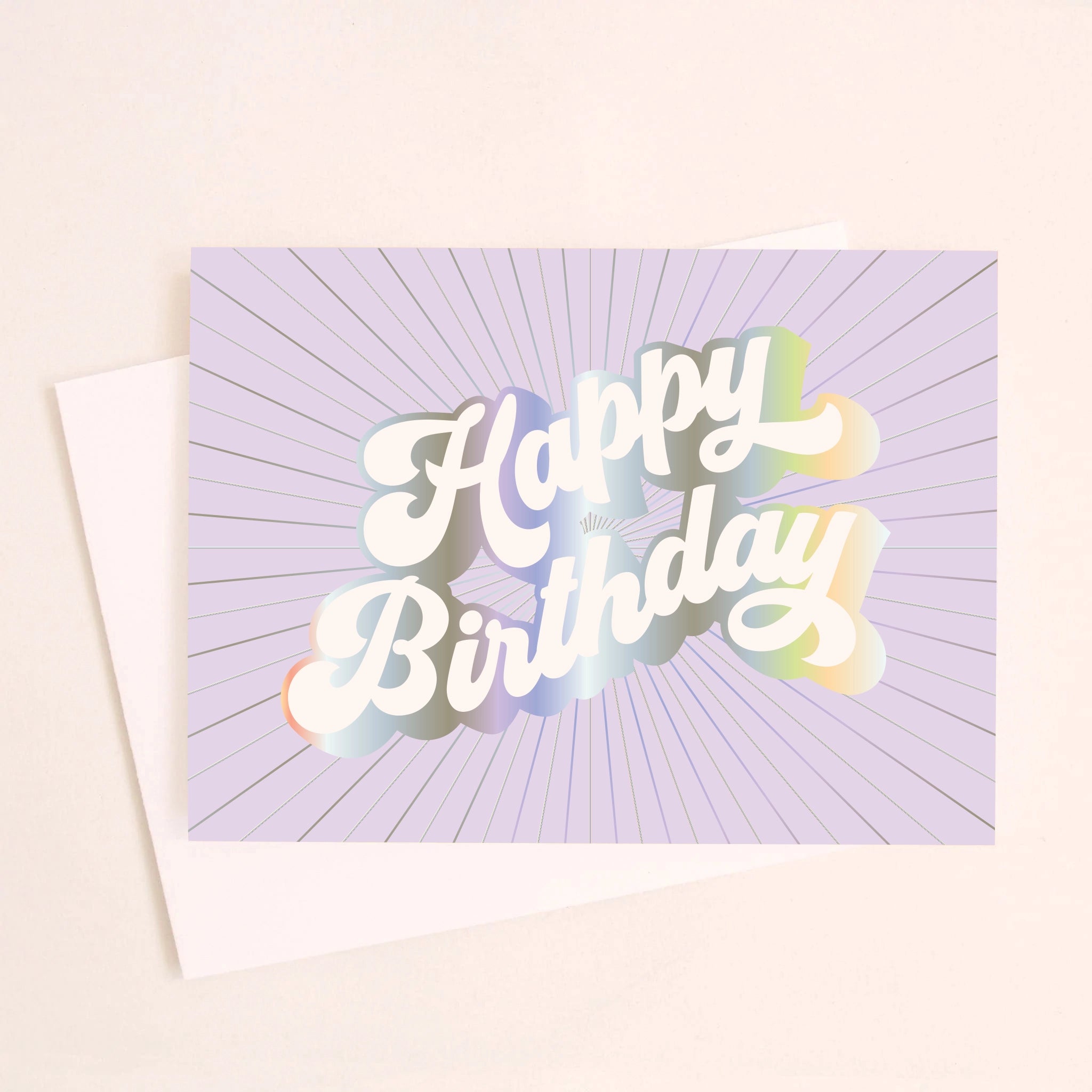 On an ivory background is a purple greeting card with white, holographic outlined text that reads, &quot;Happy Birthday&quot;.